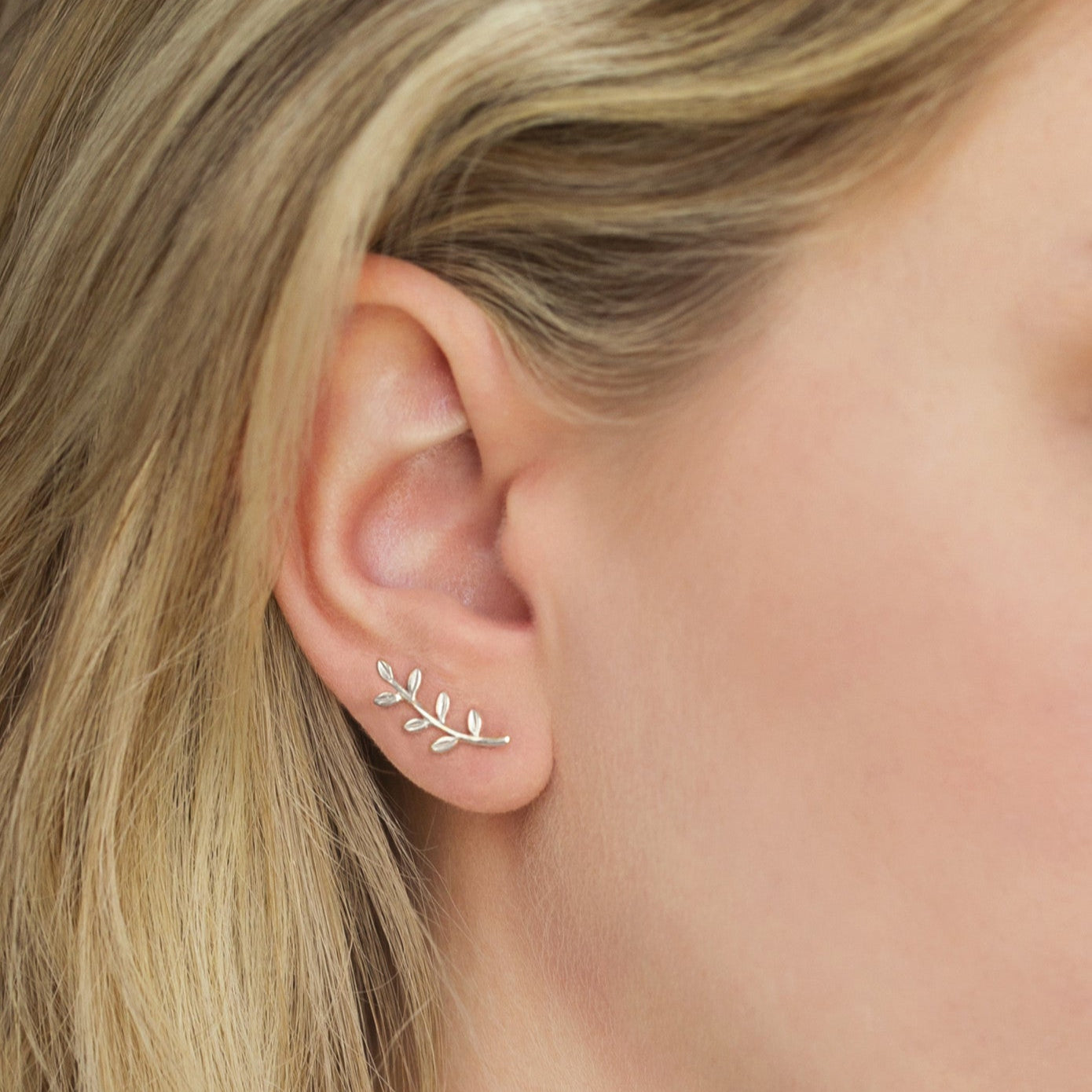 Sterling silver leaf-and-vine ear climber earring shown on a model's lobe