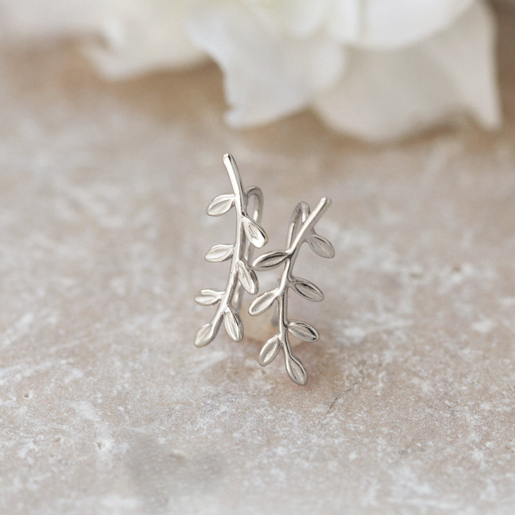 Sterling silver leaf-and-vine piece, close-up detail on a textured stone surface