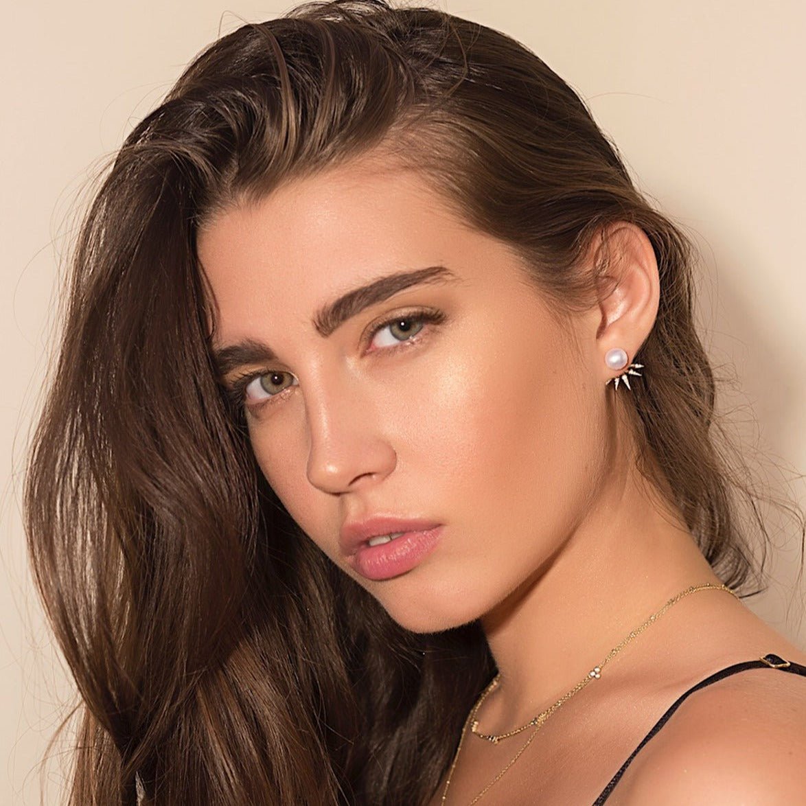 Gold vermeil pearl spike ear jacket with pavé clear stones, shown on a model's lobe