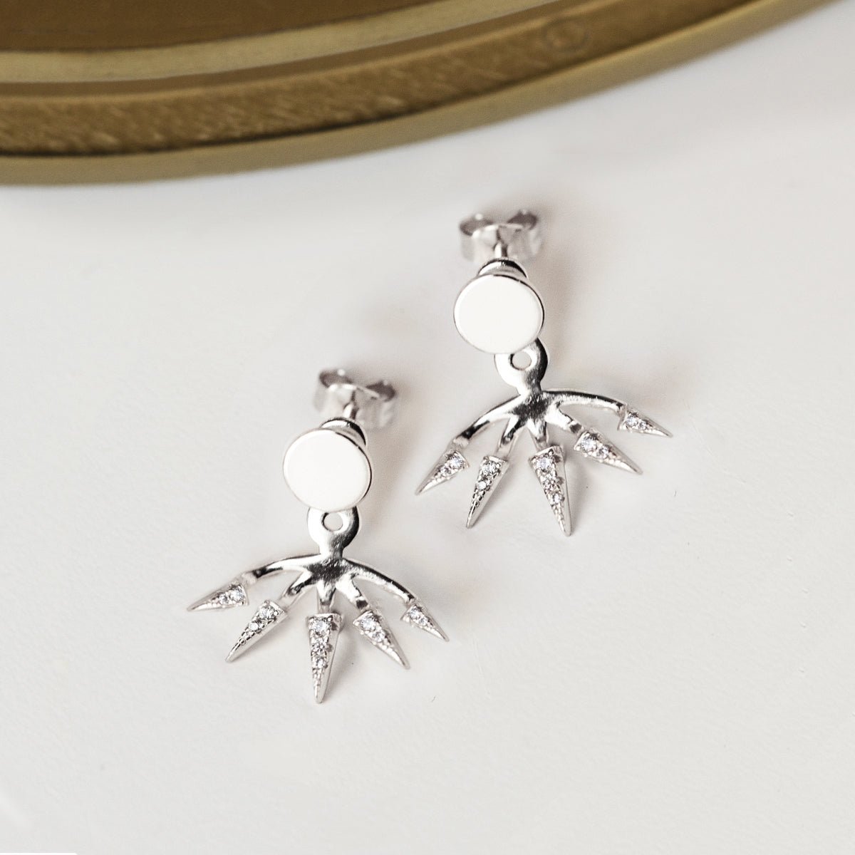 Sterling silver spike ear jacket earrings with white zirconia, shown loose beside a round case