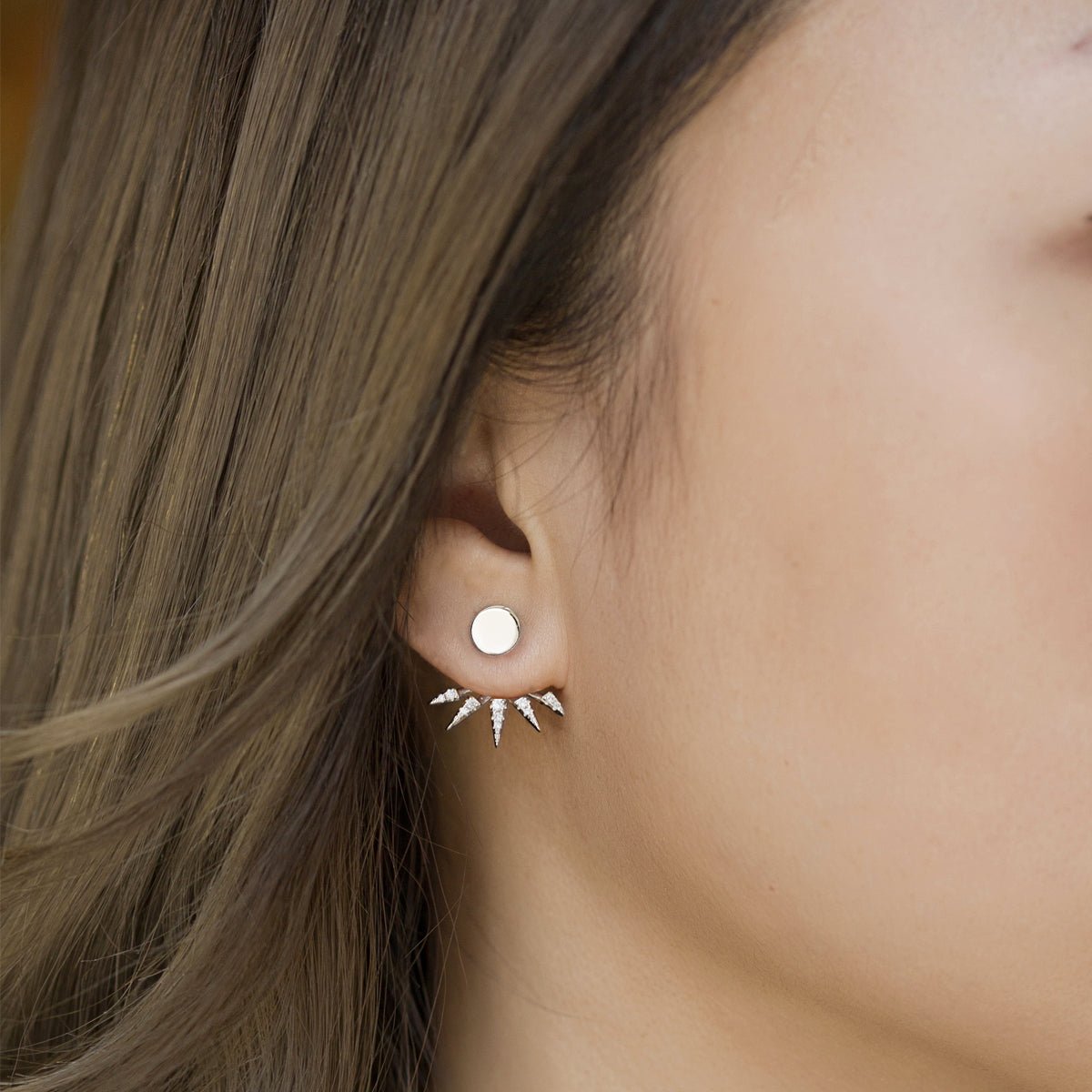 Sterling silver round stud with a white zirconia spike jacket fanned below, shown on a model's lobe