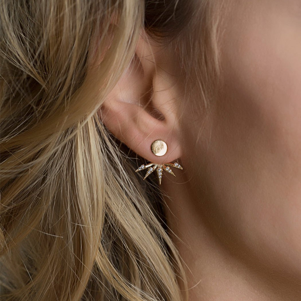 Gold vermeil spike ear jacket with white zirconia fanned below a round stud, shown on a model's lobe