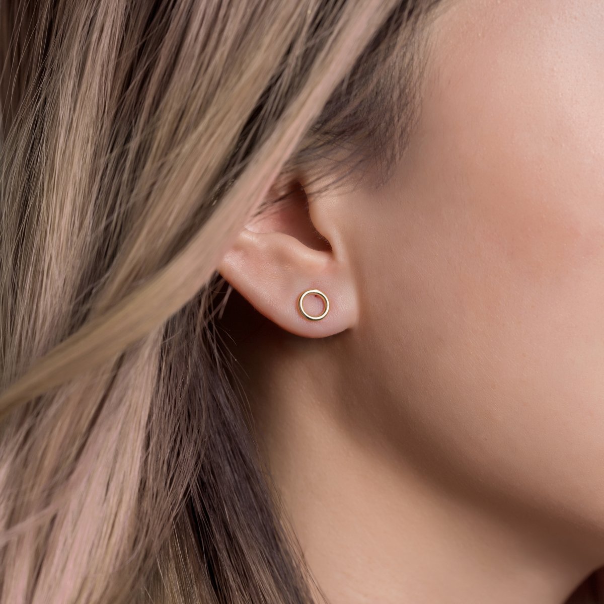 Gold vermeil open circle stud earring shown on a model's lobe
