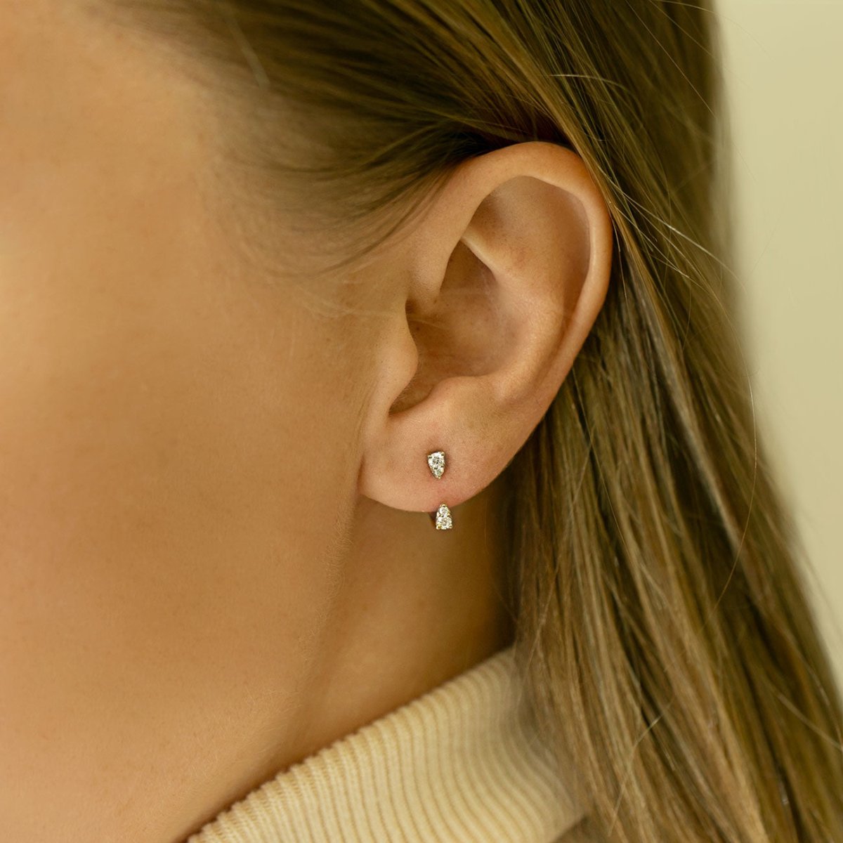 14K white gold diamond two-stone studs, shown on a model's lobe