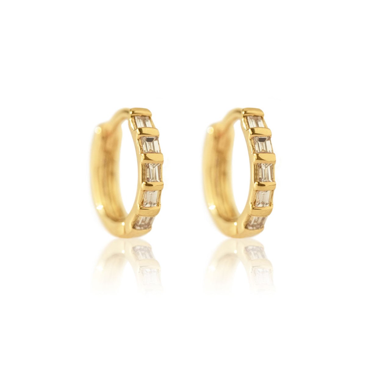 Pair of 14K gold baguette diamond huggie hoops with channel-set clear stones, on a white background