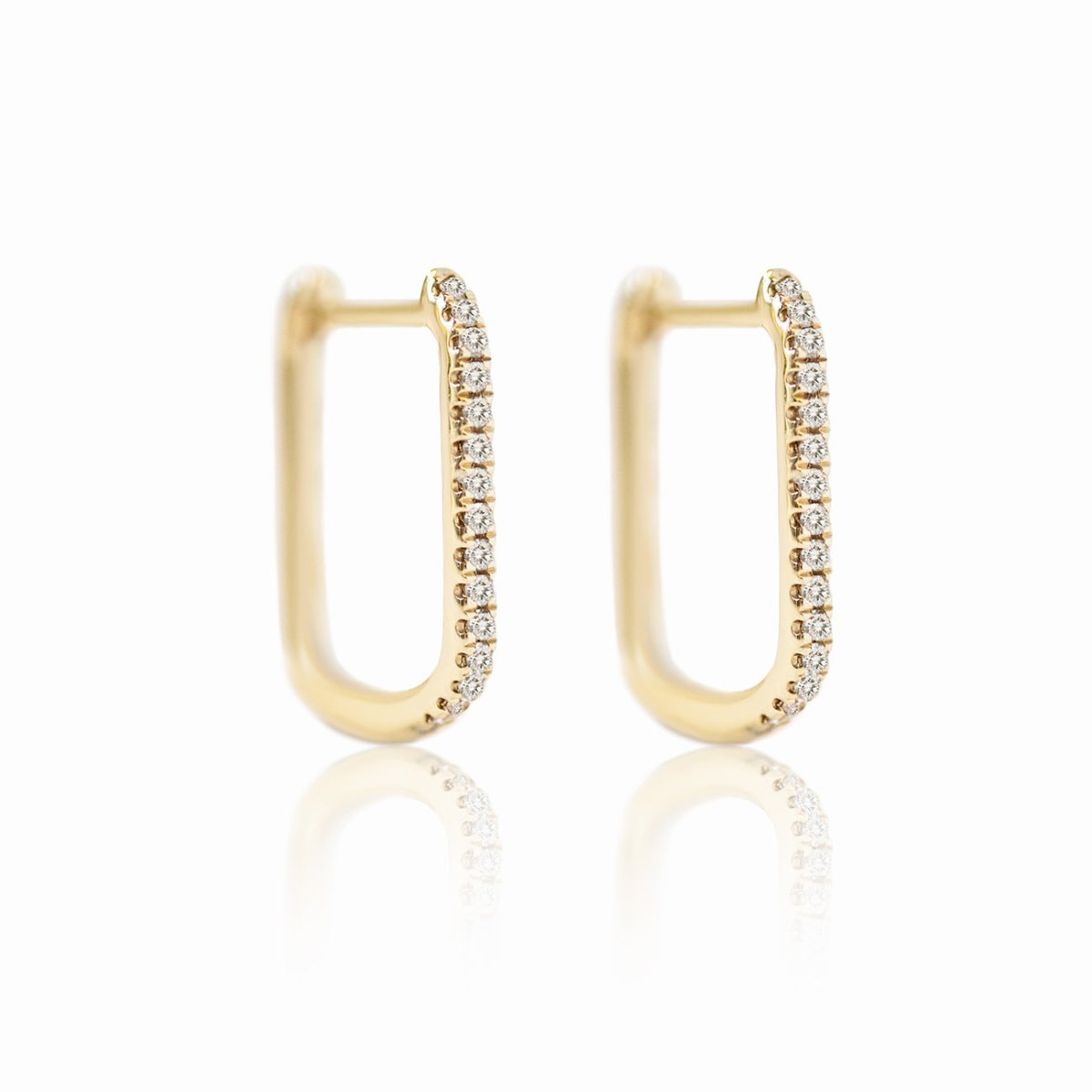 Pair of 14K gold elongated oval diamond pave hoops, on a white background