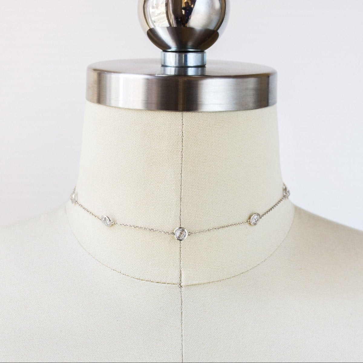 Sterling silver white zirconia station choker shown on a cream dress form