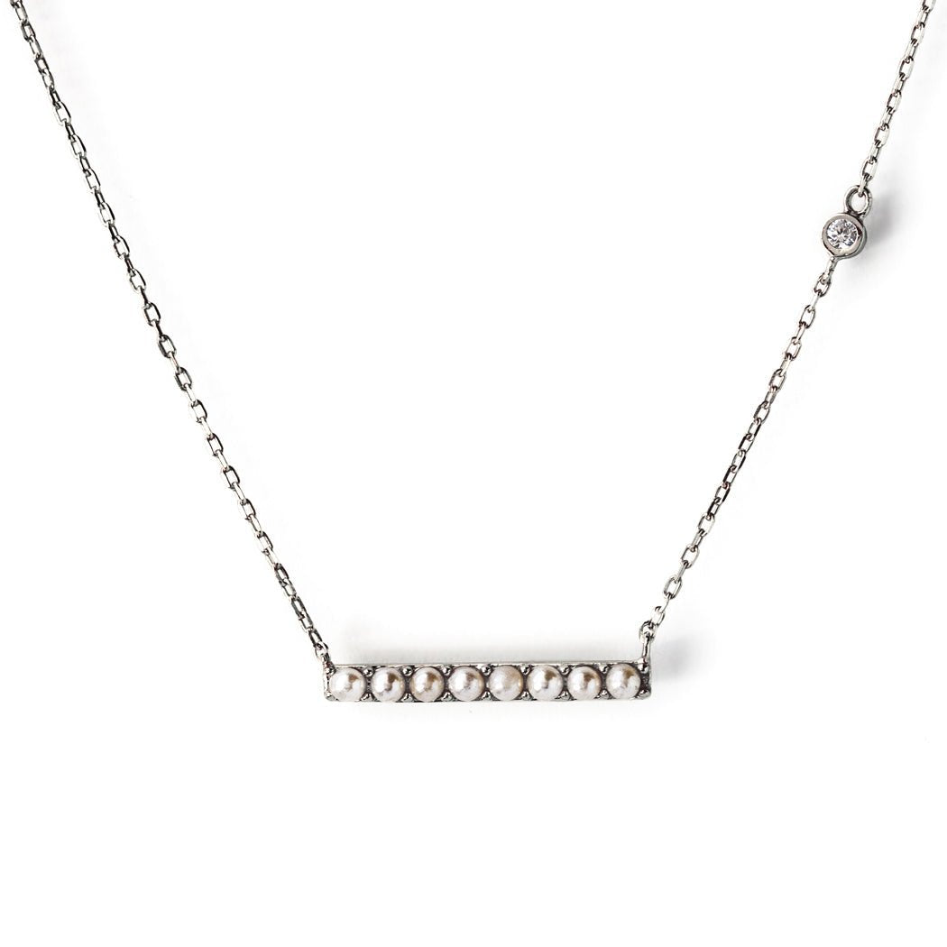 Sterling silver bar necklace lined with small pearls and a bezel-set clear stone on the chain