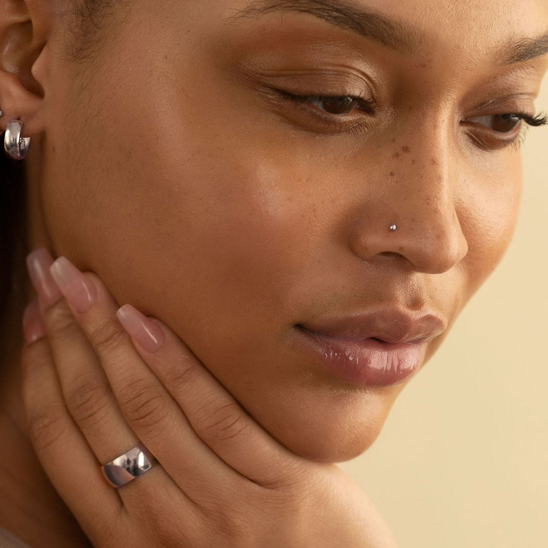 14K white gold ball nose stud and silver hoop worn by a model in profile