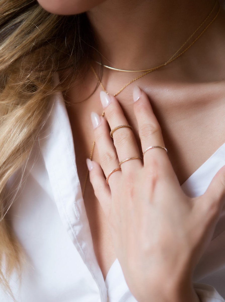 Rose gold vermeil pavé eternity ring with white zirconia, shown stacked on a model's hand