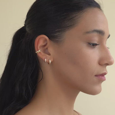 Zoomed out video of woman's side profile featuring 14K Gold Pave Huggie Hoops CZ Crystal & Gold Vermeil Eternity and Pave Ear Cuff Set. 
